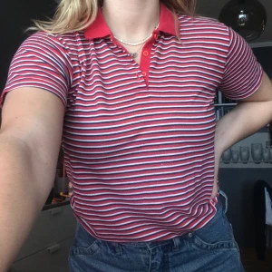 Randig T-shirt med krage - Röd Randig tröja med krage. Går att knäppa. Välanvänd i skicket därav billiga priset. Storlek M 