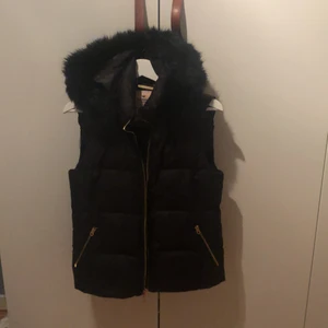 Juicy Couture väst - Säljer min svarta väst från Juicy Couture. Den är i väldigt bra skick och har en avtagbar fuskpälskrage. OBS! Skulle säga att storleken är en small trots att det står M💕