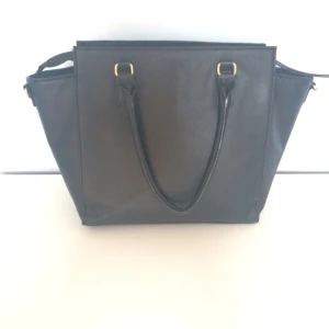  - Väska från H&M. Använd men i bra skick! Har ett fack med dragkedja och två stycken utan. Skickas mot fraktkostnad eller möts i Stockholm