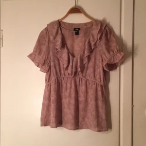  - Gammelrosa top från HM i storlek 44 med volanger. 