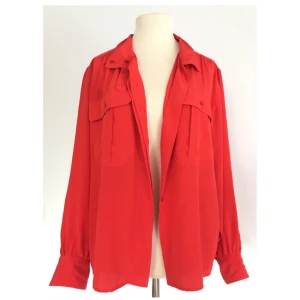  - Röd vintageblus med fina detaljer och i härligt material.   Märke: Philippe Deré Storlek: 38 Skick: Mycket gott. Aldrig använd.  Pris: 200 kronor eller bud.  Frakt: Betalas av köparen.  Mängdrabatt och samfrakt vid köp av flera plagg.