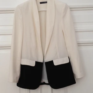  - Supersnygg svartvit kavaj i polyester. Något längre modell. Bra skick. 