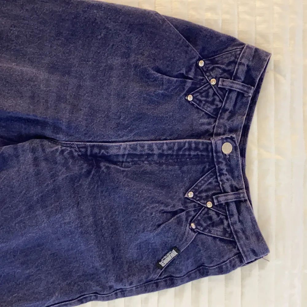Högmidjade lila jeans från Roughrider i strl S. Jag är 167 cm lång och längden är perfekt! Byxorna är i fint skick och har fina silverknappar som detaljer.. Jeans & Byxor.