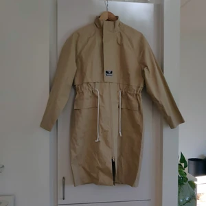 Hummel jacka i parkas modell stl s - En beige Hummel jacka i parkas modell. Storlek S. Dragkedja fram, knappar den övre biten av dragkedjan och ett snöre som går att dra åt i midjan. Helt oanvänd så lapparna sitter kvar som ni kan se på bild tre. Orginalpris 1.899 kr säljer för 900 kr. Frakt tillkommer.