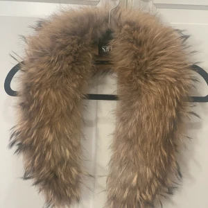 Pälskrage från Hollies - Säljer min pälskrage från Hollies med äkta päls. Den är i fint skick och går att sätta på jackor mm. (På bilden är den oborstad och har legat i en garderob)