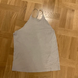 H&M linne  - Jätte fin på ryggen. Banden går i kors på ryggen. 