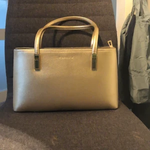 Guldväska från Susen - Helt ny handväska från susen. Aldrig använd och är i perfekt skick. Passar bra till fester eller andra tillställningar när du vill va extra fin!Inköppt för 399kr, nu 100! Kan skicka fler bilder om det efterfrågas. 