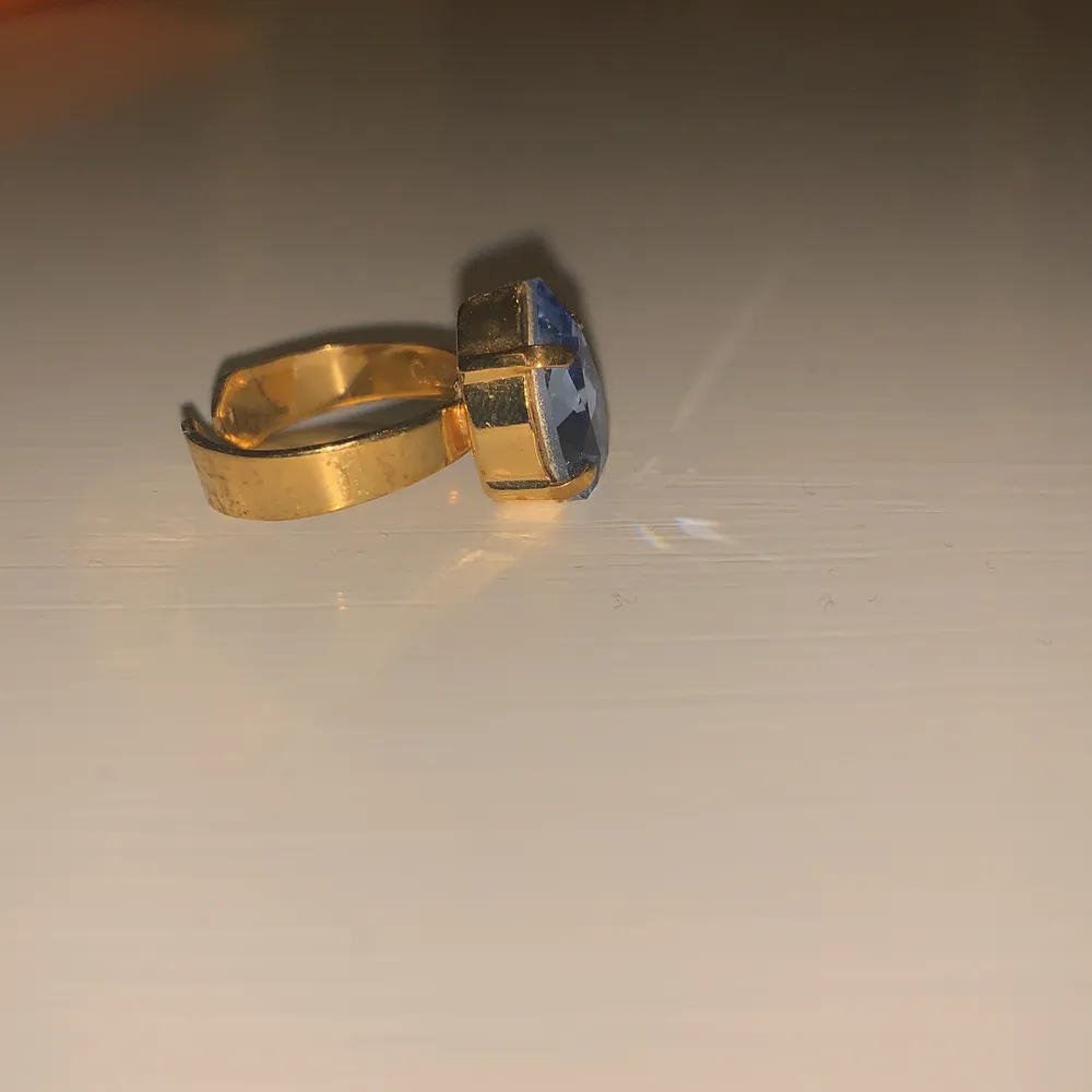 Smalare ring i guld med en blå Sten. Använd 3 gånger. Justerbar. Accessoarer.