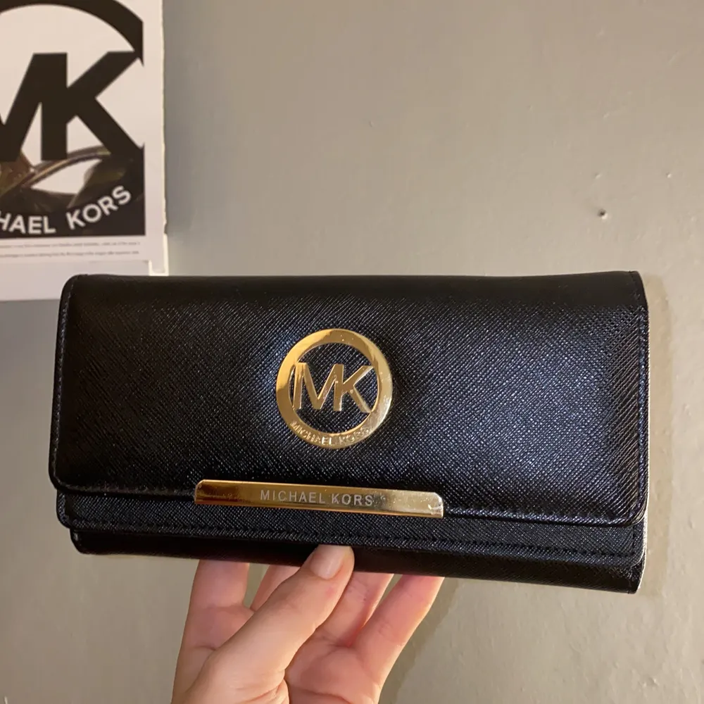 En skit snygg micheal kors plånbok i svart med guld. Vet inte om den är äkta eller inte då min mammas kompis köpte den som en present. . Väskor.