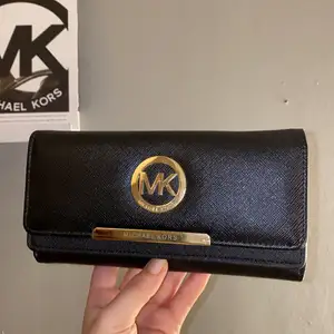 En skit snygg micheal kors plånbok i svart med guld. Vet inte om den är äkta eller inte då min mammas kompis köpte den som en present. 