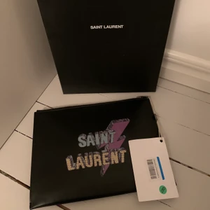 Saint Laurent Clutch  - Säljer oanvänd clutch, passar även IPad. Tag kvar, kartong, dustbag finns. 4000kr 