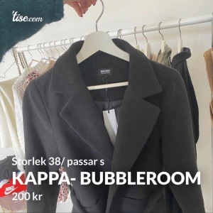 Kappa- Bubbleroom - En superfin svart kappa ifrån Bubbleroom x Moa Mattsson. ( ett fint bälte med silverdetalj med ) ⚡️ Helt oanvänd, tyvärr! Har ej kommit till användning💖 Storlek 38, men skulle säga att den passar en S. Säkert M också, beror på hur man vill att den ska sit