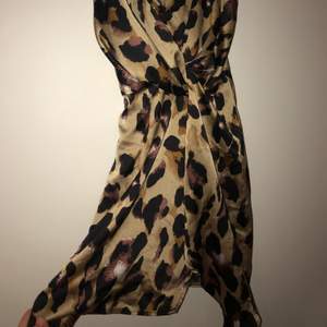 Leopardmönstrad sidenklänning, går omlott med en liten slits.