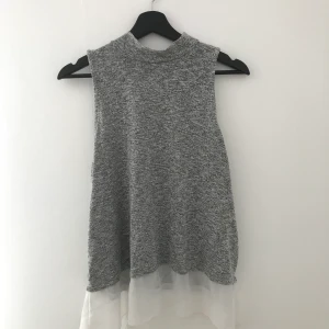 Grått linne - Grått linne med vit ”lace” längst ner, storlek L, bra kvalitet nästan helt oanvänd. Säljer pga att jag inte använder den.