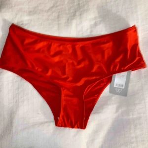  - Bikinitrosor i en röd/orange färg. 