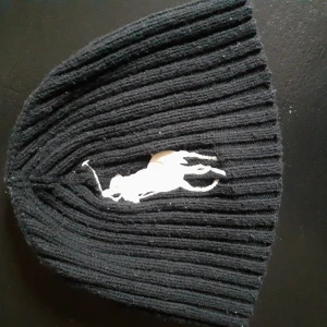 Ralph Lauren mössa one size  - Använd men i fint skick hel o h ren äkta Ralph Lauren mössa svart med vita loggan. 100 sek ink frakt