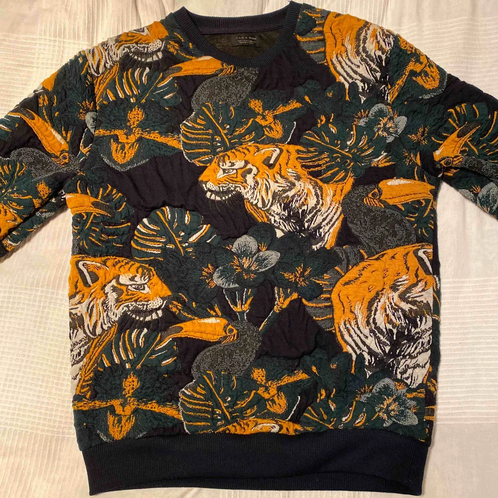 Marinblå sweatshirt med ”bakgrund” av tigrar på. Storlek S men passar mig som i vanliga fall har M. Fin tröja med fina mönster.. Hoodies.