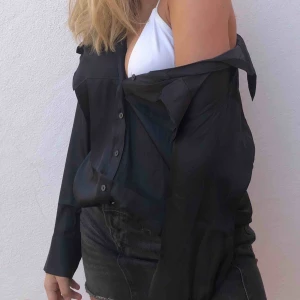  - Svart glansig skjorta från H&M. Superbra skick, knappt använd. Köparen står för frakt!