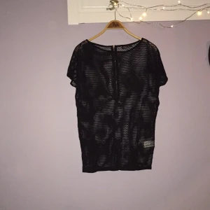  - Svart nät tröja från Lindex.
Guldfärgad  dragkedja på ryggen.
OBS de svarta "vågorna" på tröjan är egentligen inte där!