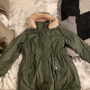 Lindex - Jag säljer denna jacka på grund av att jag inte använder den, den är i storlek 164 och i gott skick;) Den har en fluffig luva och åtdragningar i midjan det är dock ett håll i varje ficka:( Men annars är den i gott skick👍🏼