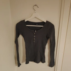 Ribbad tröja - En grå ribbad långärmad tröja med urringning. Frakt ingår ej. 