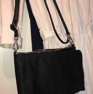 Basis handväska! - En liten och perfekt handväska! Olika fack med både knapp och dragkedja, går att ha kort över axeln eller över bröstet. Det går också att ta av banden för att bara hålla den i handen då den e väldigt tunn. Använd ganska mycket förut men inga som helst fel på väskan 
