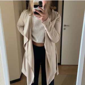 Beige Kappa - Den är beige -Kappan är modern, fin & Classy. tyvär säljer pga fel storlek.