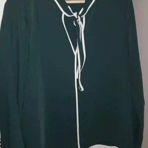 Mörkgrön Blus från Zara - En mörgrön 60-tals inspirerad blus från Zara med snygga vita detaljer och en knut vid halsen. Använd ett fåtal gånger (nästan helt ny). Säljes för 100kr men frakt får ni stå för💖💖