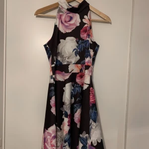 Blommig klänning  - Klänning med choker-liknande hals och öppen rygg. Jättefin kvalitet. (+frakt)