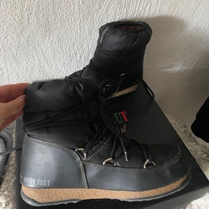 LÅGA MOON BOOTS 39 - Säljer mina otroligt sköna Moonboots, använd ett få tal gånger och i nästintill oanvänd kvalité. Köpta i en butik för 1800kr, för ett år sedan. Säljer pågrund av flytt :) Kartong medföljer. Möte eller frakt :) i färg black/Bronze