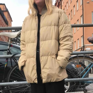  - M/L eller oversize beige dunjacka, mörkblått foder