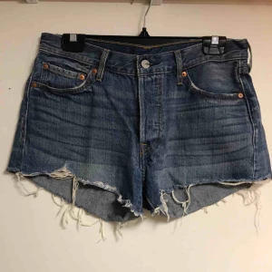 - Blå spräckliga jeans shorts från Levi’s med lite slitningar vid fickorna. Knappar som gylf, som ni se på sista bilden.  Frakt tillkommer.