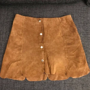  - Äkta läderkjol med guldknappar på. Inhandlad från Mango. Jättefint skick. Säljes för 200 kr. Kan mötas upp på Södermalm/T-centralen eller skickas inom Sverige. Köparen betalar för frakten. 
