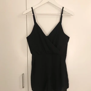  - En svart v-ringad playsuit. 100kr + frakt. 