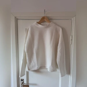  - Vit ribbad tröja med halvhög hals. 