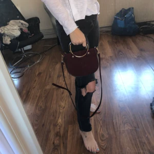  - Den PERFEKTA väskan till hösten. Supersnygg riktigt höstig vinröd väska från Lindex. Axelbandet är avtagbart så den går att använda som både axelbandsväska och handväska. 