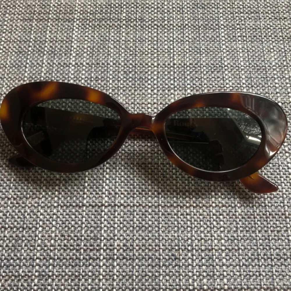 Fantastiskt fina solglasögon från franska varumärket Rouje. Brunmelerade bågar och mörkgrönt/gråaktigt glas. Ger 100% skydd mot stark sol utan att helt täcka ögonen. Inköpta i början av sommaren för 1400kr. Mycket gott skick! . Accessoarer.