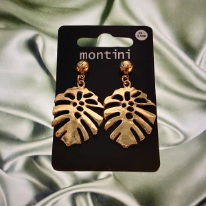 Örhängen  - Ett par guld örhängen som är formande som palmblad. Aldrig använda. Oäkta.                        + 10kr i frakt.