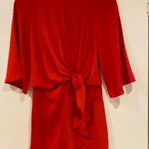 Röd kort klänning med knytdetalj. Storlek 36. Använd en gång, fint skick! 