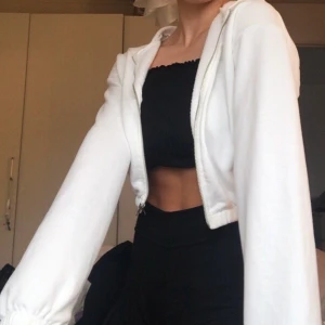 Vit croppad kofta - ❤️Vit lite croppad zip hoodie/ kofta från nelly!  Har använt den nån gång så är som ny men säljer för att jag har flera liknande🥰 liknar den från brandy melville! skriv för fler bilder eller frågor. BUD PÅ 220 BUDA HÖGRE ELLER KÖP DIREKT FÖR 250 KR  (nypris 300kr)