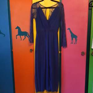 Snygg lång blå klänning med spets armar och spets i en del av ryggen 