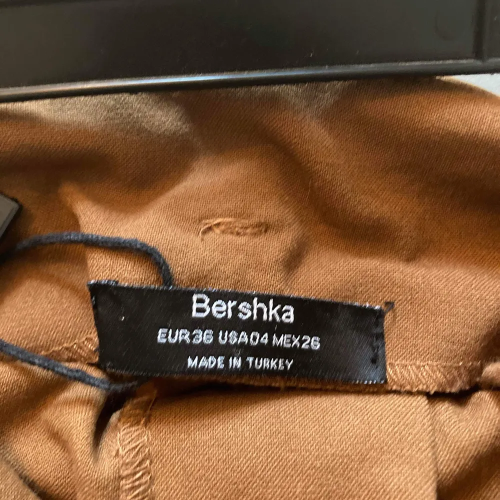 Säljer ett par bruna paperbag byxor från Bershka. Köpta för två år sen, men har inte använts på ett år. Byxorna är högmidjade men lite kortare i längden på mig som är 168 cm. Säljer för 100 kr och köparen står för frakt (65kr). . Jeans & Byxor.