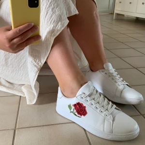 Vita sneakers med broderad blomma  - Vita sneakers med broderad blomma från Claudia Ghizzani i fint skick, säljs pga för små. Du står för ev frakt (: