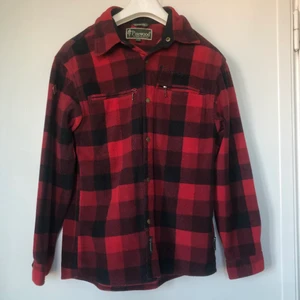 Röd rutig pinewood jacka - Använder inte längre, köpt för ett tag sen. Skön i materialet och inga skador eller slitningar. Ganska mörk i färgen perfekt t hösten. Strl S 
