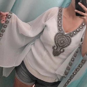 Plain Vanilla tunika - Ljuvlig tunika i ljusblått från Plain Vanilla. Strass kring ärmar samt dekolletage i strl: S. Är själv en M/L så passar flera storlekar. 