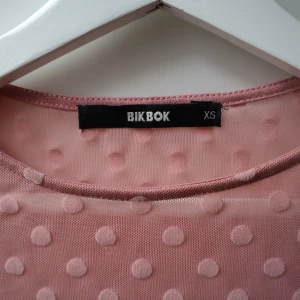 body, storlek xs - Jättefin body i rosa med prickar på, köpt på BIK BOK, knappt använd i storlek XS 💘