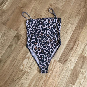 Body från boohoo strl 34 - Säljer denna fina body från boohoo. Den har leopard mönster på sig. Strl 34. Har använt den 2-3 ggr så den är i väldigt bra skick! Den är väldigt högmidjad så man måste ha höga jeans ifall man inte vill att man ska se kanten. Säljer för 50kr men priset kan diskuteras 