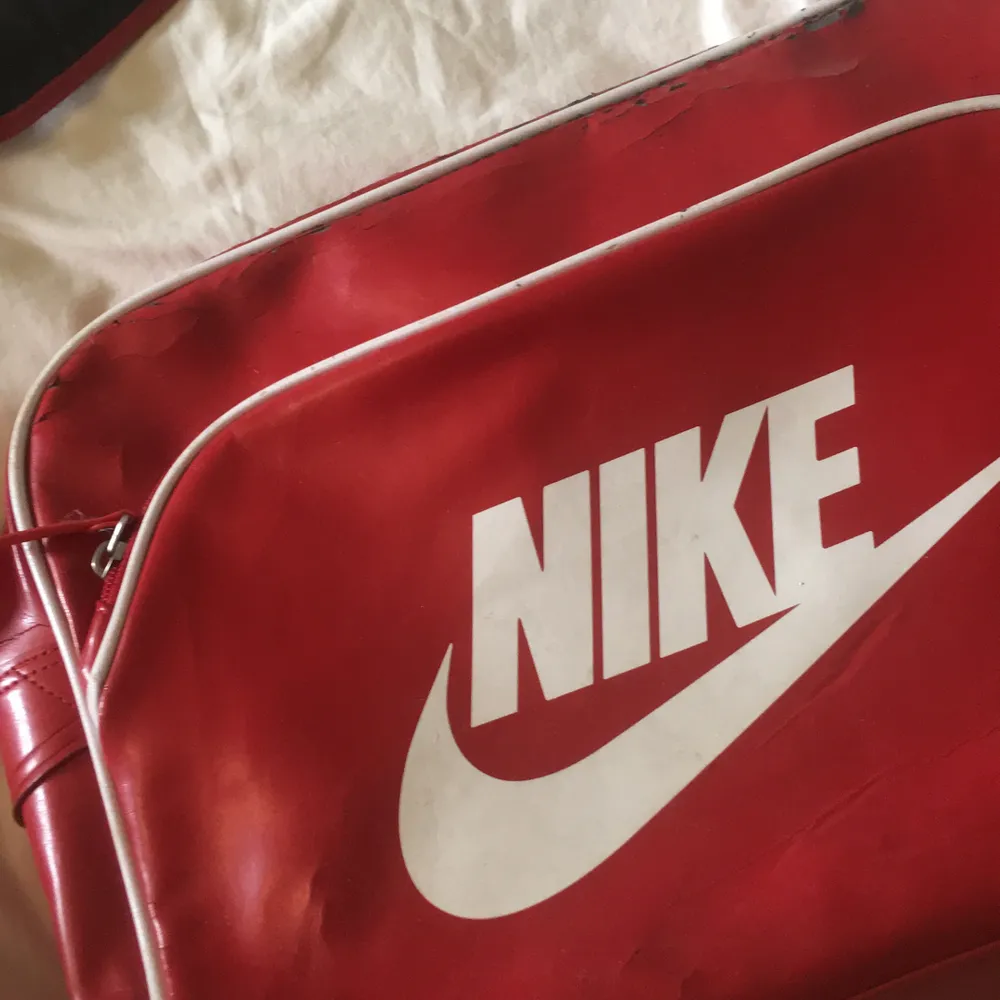 En röd, vintage, Nike axelväska❤️ Många fack, perfekt för träningen eller skolan! Mycket sprucken, men det inger patina tycker jag☺️ Den har fortfarande kvar att ge! . Väskor.