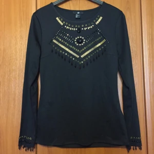 - Festlig svart tröja med pärlor i Strl M från H&M. Aldrig använd. Ni står för frakten om vi inte möts upp.