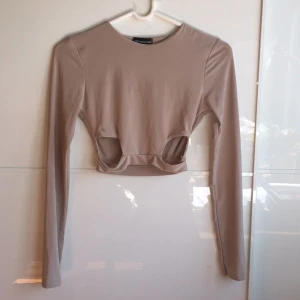  - Beige crop top i silkigt material. I nyskick! Färgen är som sista bilden. Betalning via swish och frakt tillkommer. 